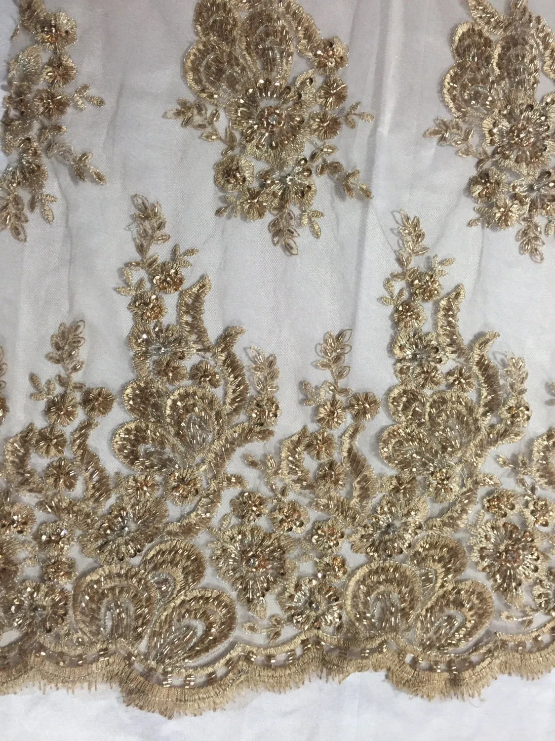 Metallic gold flowers embroider and heavy beaded on a mesh lace fabric-sold by the yard-